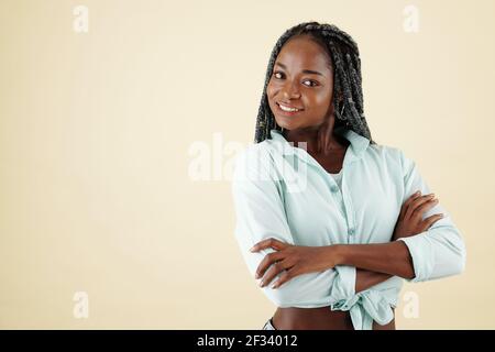 Porträt einer glücklichen selbstbewussten jungen Frau mit toothy Lächeln Falten Arme und Blick auf die Kamera Stockfoto
