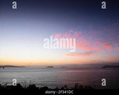 Rosafarbene Sonnenaufgangswolken über der Frenchman Bay und dem südlichen Ozean, mit Michaelmas & Breaksea Islands am Horizont, Albany, Western Australia Stockfoto