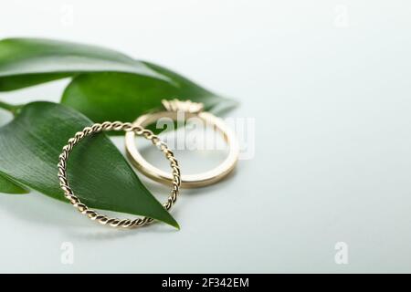 Blätter und goldene Ringe auf weißem Hintergrund Stockfoto