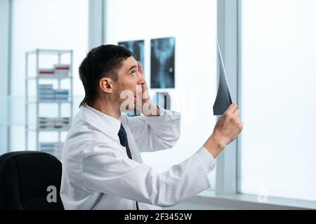 Überraschte den Arzt, der die Röntgenaufnahme des Patienten betrat. Stockfoto