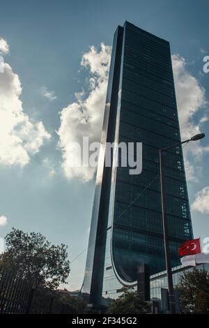 Türkische Flagge, Laterne und Bäume in der Nähe von Wolkenkratzern gegen bewölkten Himmel in Istanbul, Türkei Stockfoto