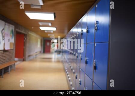 Blaue Schließfächer im leeren Schulflur Stockfoto