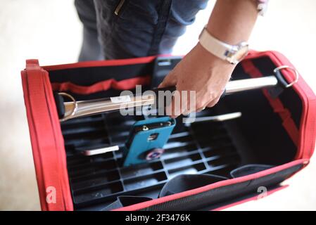 Mann hält einen roten Werkzeugkasten, um an der Reparatur zu arbeiten Stockfoto