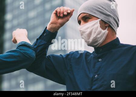 Nahaufnahme. Zwei junge Männer grüßen sich mit ihren Ellbogen Stockfoto