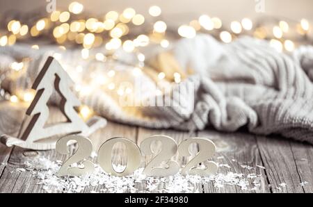 Das Winterstillleben mit der dekorativen Nummer des kommenden Jahres auf der hölzernen Oberfläche mit den dekorativen Elementen vor dem verschwommenen Hintergrund. Stockfoto