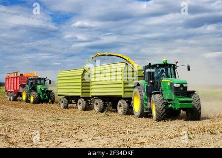 John Deere Traktor Anhänger bei der Arbeit Ernte Mais Deutschland Traktoren landwirtschaftliche Maschinen Stockfoto