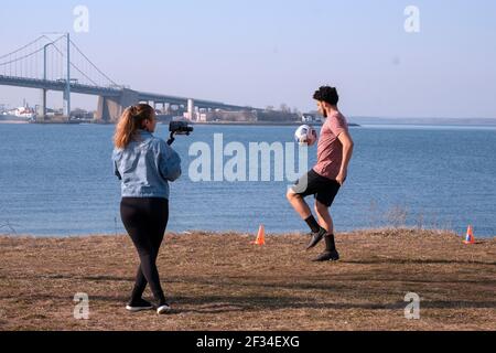 Ein College Varsity Fußballspieler wird an einem warmen Wintertag gefilmt. Im Little Bay Park in Whitestone, Queens, New York City. Stockfoto