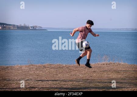 Ein kollegiale Fußballmannschaft spielt an einem malerischen Ort im Little Bay Park, Whitestone, Queens, New York City, Übungen. Stockfoto