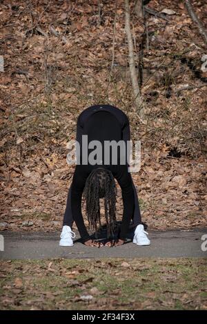 Eine flinke, flexible Frau in den Fünfzigern führt täglich einen meditativen Yoga-Kurs in einem Park in Queens, New York City. Stockfoto