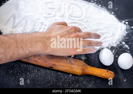 Muslimischer Mann schreibt eid mubarak mit Mehl Stockfoto