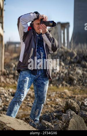 Professioneller Fotograf, der zwischen Industrieruinen fotografiert Stockfoto