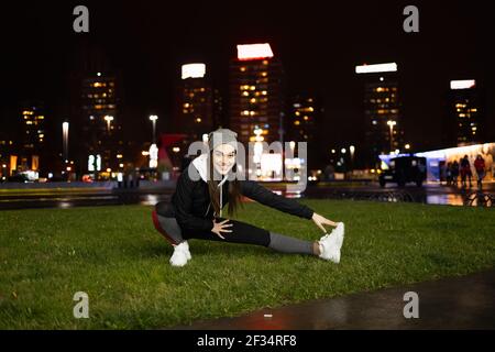 Weibchen streckt ihre Beine als Warm-up vor dem Abendtraining Stockfoto