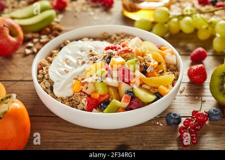 Hoher Winkel von köstlichen Müsli mit verschiedenen Beeren und frisch Obst auf dem Tisch in der Küche zum Frühstück Stockfoto