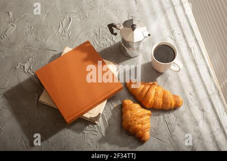 Stillleben für angenehmen Morgenkaffee türkischbecher und Croissants mit zwei Büchern auf dem Tisch. Mittagspause Konzept oder beginnen Sie den Morgen Stockfoto