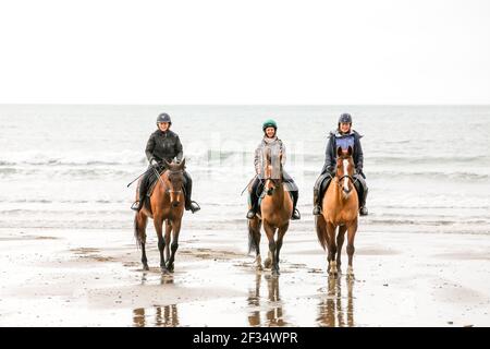 Red Strand, Cork, Irland. März 2021, 15th. Lisa Brinkmann, Niamh Morrison und Doris May reiten an einem ruhigen Morgen in Red Strand, Co. Cork, Irland. -Credit David Creedon / Alamy Live Nachrichten Stockfoto