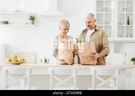 Hausarbeiten, Haushaltung, Kauf zusammen in der Freizeit, paar Auspacken frische Produkte aus dem Markt in der Küche Stockfoto