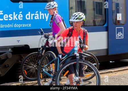 Zwei junge Frauen, die mit dem Fahrrad auf einem Bahnsteig unterwegs sind Tschechische Republik Ceske Drahy Eisenbahn Stockfoto