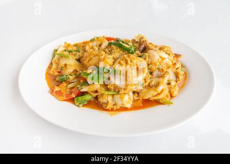 Gebratene Tintenfische mit Curry-Pulver auf einem weißen Tisch Thai-lokale Küche, Nahaufnahme von oben. Stockfoto