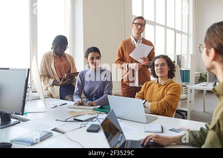 Porträt eines vielfältigen IT-Entwicklungsteams, das während der Arbeit über das Projekt spricht Bei der Softwareproduktion im Büro Stockfoto