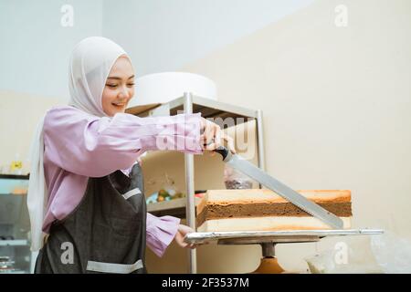 Schöne junge Bäcker machen Kuchen in ihrer Küche Stockfoto