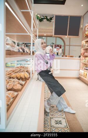 Schöne junge Frau hijab lächelt stolz auf ihr Geschäft Stockfoto