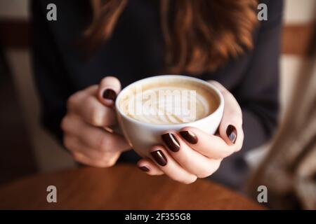 Kaffee in den Händen der Frau Stockfoto