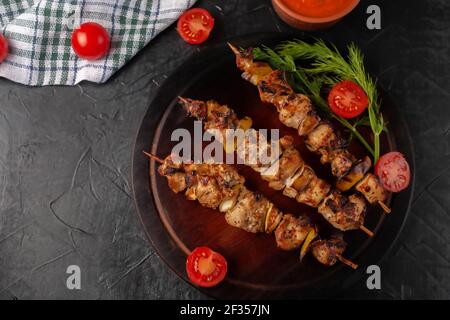 Hähnchenspieße mit Äpfeln und Gemüse auf schwarzem Hintergrund Stockfoto