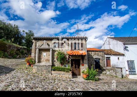 Belmonte, Portugal; Mai 2017 : verlassene Gasse und charmantes altes kleines Haus mit Steinnische für Heilige, an einem sonnigen Tag in Belmonte. Eine niedliche kleine Stadt, Stockfoto