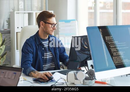 Seitenansicht Porträt der modernen IT-Entwickler mit Computer im Büro während der Arbeit an VR-Spiele und Software, Kopierraum Stockfoto
