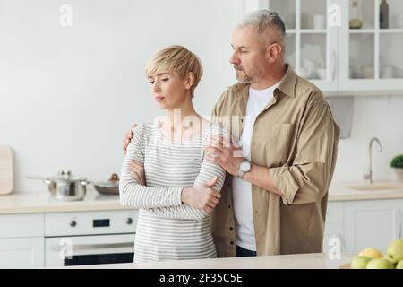 Beruhigende Ehepartner nach Streit oder schlechte Nachrichten, menschliche Emotionen und Probleme in Familienbeziehungen zu Hause Stockfoto