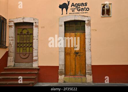 Typische handwerkliche Ladenfassade mit Stuckwand, antiker Holztür und handgemaltem Schild in Zacatecas, Mexiko. Stockfoto