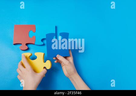 Draufsicht Hände eines autistischen Kindes Ordnen Farbe Puzzle Symbol des Bewusstseins für Autismus-Spektrum-Störung. Autismus-Bewusstsein Tag oder Monat. Stockfoto