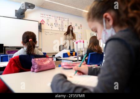 Lissabon, Portugal. März 2021, 15th. Ein Lehrer mit Gesichtsmasken gibt am 15. März 2021 in Oeiras, Portugal, einen Kurs in der Schule von Gomes Freire de Andrade ab, während die Schüler nach einer obligatorischen Sperrzeit aufgrund der Covid-19-Pandemie in den Unterricht zurückkehren. Die portugiesische Regierung hat einen vierstufigen Plan zur Lockerung der COVID-19-Beschränkungen im Laufe des Impfprogramms aufgestellt, wobei die erste Stufe am 15. März mit der Wiedereröffnung von Kindergärten, Kindergärten und Grundschulen sowie Friseuren, Barbierläden und Buchhandlungen beginnt. Quelle: Pedro Fiuza/ZUMA Wire/Alamy Live News Stockfoto