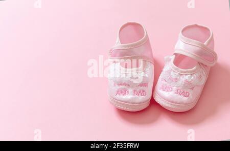 Babydusche, Mädchen Taufe Konzept. Baby rosa Schuhe auf rosa Farbe Hintergrund. Es ist ein Mädchen Neugeborenen Ankündigungsvorlage. Weiche weibliche Fußwea für Kleinkinder Stockfoto