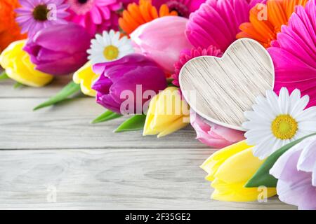 Herz und Tulpen vor Holzhintergrund Stockfoto