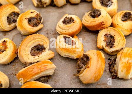 Frisch gebackene goldene Patties mit Pilzen auf Backpapier. Stockfoto