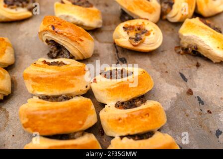 Frisch gebackene goldene Patties mit Pilzen auf Backpapier. Stockfoto