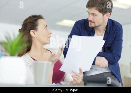 Fokussiertes besorgter Paares mit Dokumenten, die zusammen auf dem Sofa sitzen Stockfoto