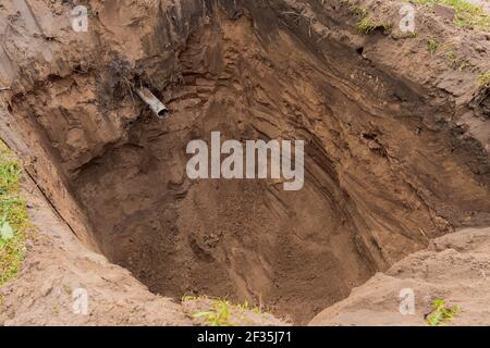 Tiefe Grube im Boden auf einer Baustelle aus nächster Nähe. Stockfoto