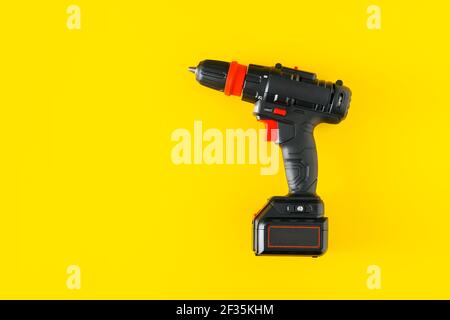 Handheld Akku-Bohrmaschine auf gelbem Hintergrund Stockfoto