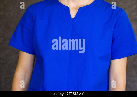 Ein männlicher Arzt trägt eine blaue Uniform für Operationen verwendet Stockfoto
