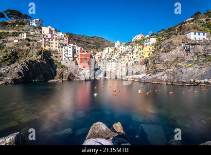 Reihen von bunten Häusern auf steilen Felsklippen über dem Meer gebaut. Tiefer Winkel am Morgen Blick auf M. Cinque Terre, Ligurien, Italien. Stockfoto