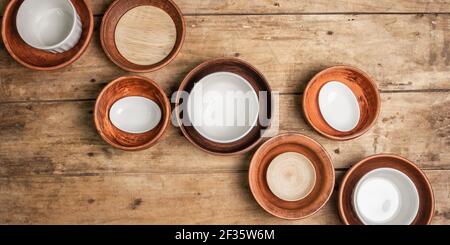 Handgemachte leere Keramikgeschirr und Teller auf Holzhintergrund. Sammlungen von verschiedenen Schalen, traditionelle Volksverzierung, rustikalen Stil, Vintage-Tisch. P Stockfoto