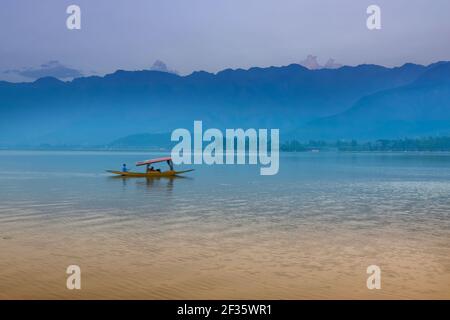 Spiegelung der Himalaya-Berge am Dal Lake, Srinagar, Jammu und Kaschmir, Indien. Hausboote schwimmen am späten Nachmittag auf dem See. Stockfoto