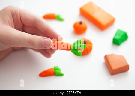 Ein kleiner Junge, der Fimo-Gemüse macht. Geringe Schärfentiefe. Nahaufnahme. Stockfoto