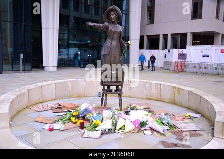 Plakate, die für die Sicherheit der Frauen Lobby und Blumen an der Statue von Emmeline Pankhurst in St. Peter's Square, Manchester, England, Großbritannien, links nach der Mahnwache in Erinnerung an Sarah Everard am 13th. März, 2021. Ein Londoner Metropolitan Polizeibeamter wurde wegen Sarah Everards Entführung und Ermordung am 12th. März angeklagt. Er erschien am 13th. März vor dem Amtsgericht Westminster und wurde in Gewahrsam genommen, um am 16th. März im Old Bailey zu erscheinen. Emmeline Pankhurst war die Führerin der Frauenrechtbewegung im Vereinigten Königreich. Die Bronzestatue wurde von Hazel Reeves modelliert. Stockfoto