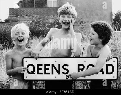 Junge Jungen, die über den Rechtschreibfehler lachen, den der rat auf der Queens Road in Dudley, Großbritannien, Großbritannien, den 1970er Jahren gemacht hatte, schlechter Rechtschreibfehler Legasthenie glückliche Jungen, die lächelten Stockfoto