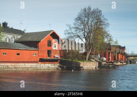 Alte rote Holzhäuser und Scheunen befinden sich an der Flussküste im historischen Teil der Stadt Porvoo, Finnland Stockfoto