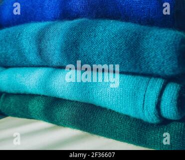 Nahaufnahme des organisierten Stapels von blau zu grün Kleidung mit Farbverlauf Stockfoto