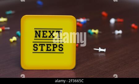 NÄCHSTE SCHRITTE. Text auf dem Hintergrund des Tisches und verstreute Stecknadeln. Geschäftskonzept, Strategie, Plan, Planung. Stockfoto